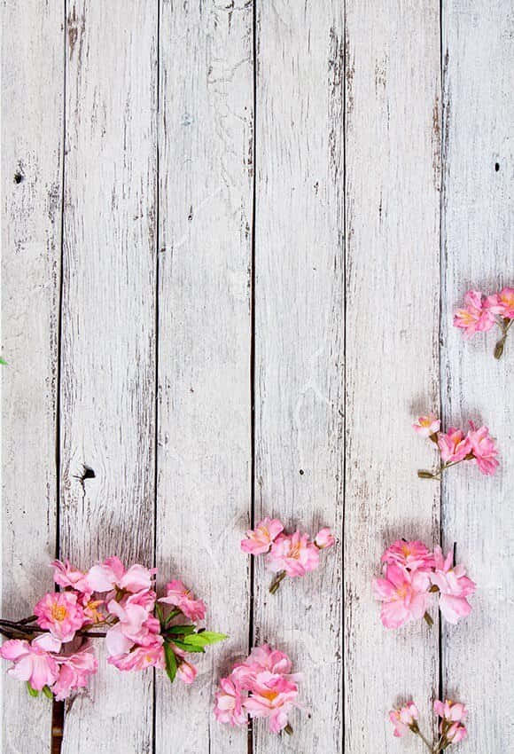 A White Wooden Background With Pink Flowers And A Flowerpot