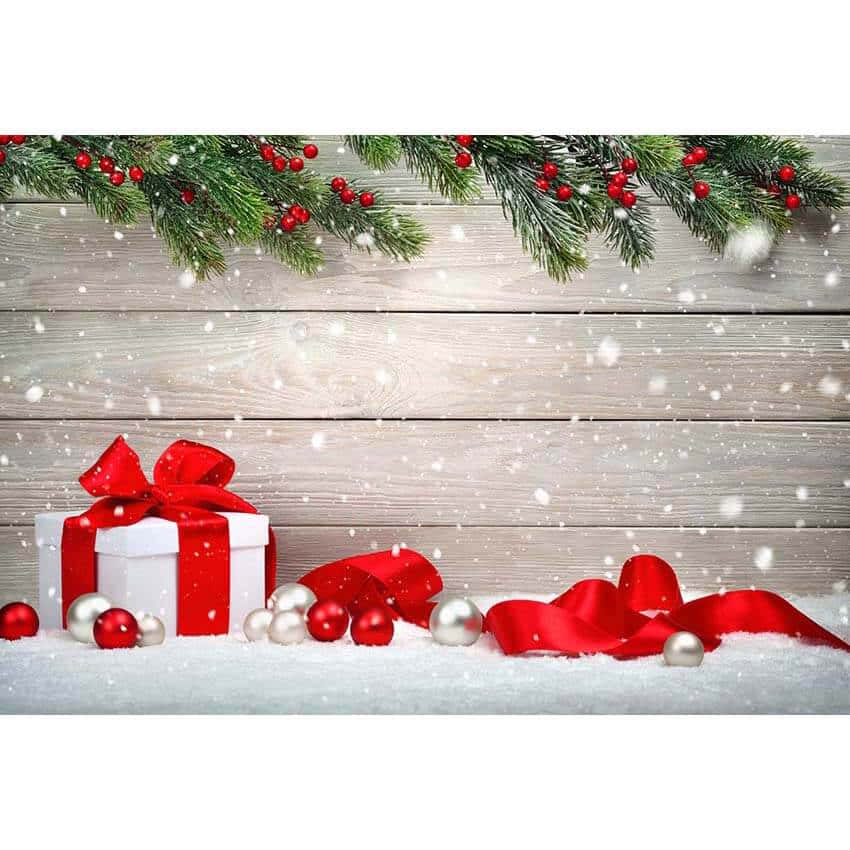 Christmas Gift Box With Red Ribbon And Baubles On A Wooden Background