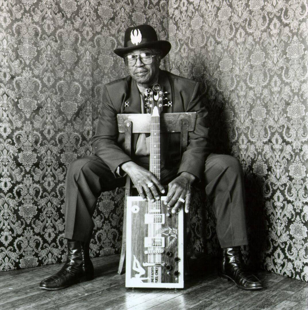 Greyscale Bo Diddley Sitting On Chair Wallpaper