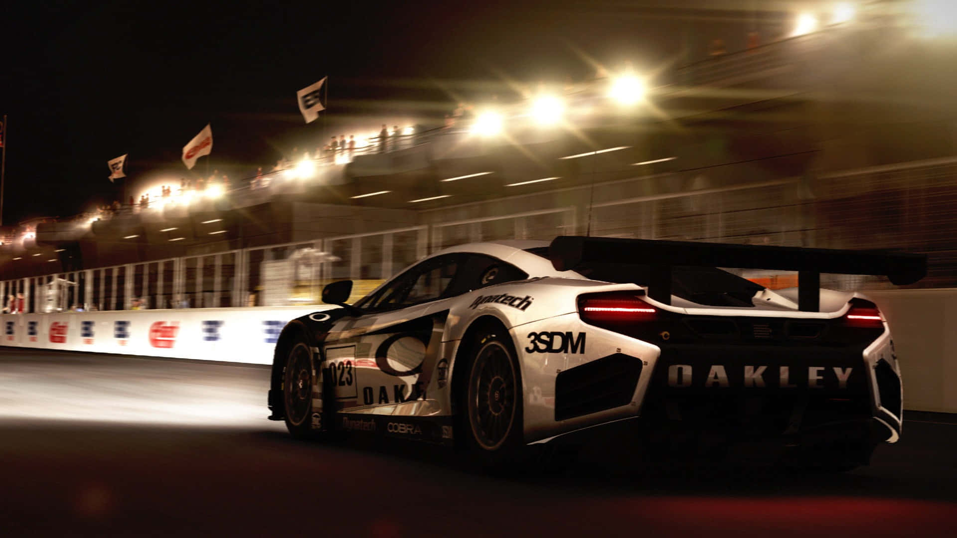 A White And Black Racing Car Driving On A Track At Night