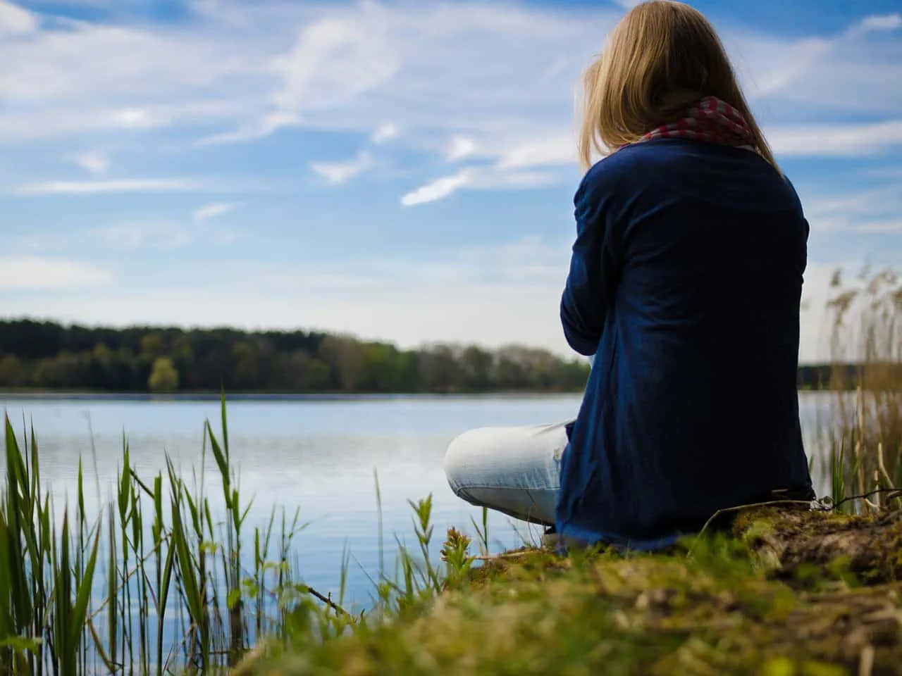 Woman Sitting On The Edge Of A Lake