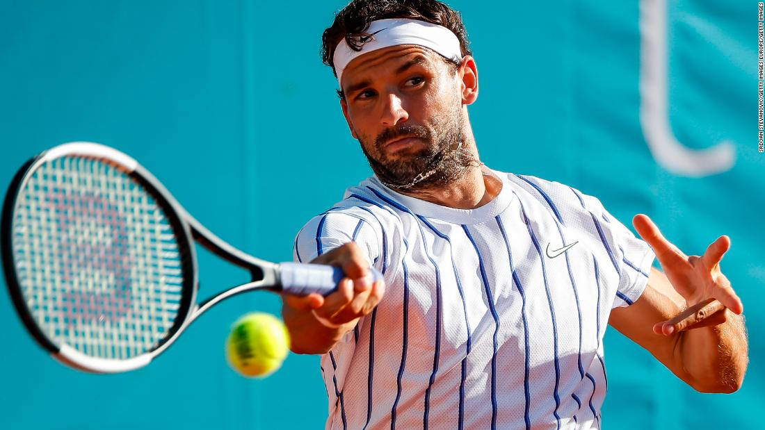 Grigor Dimitrov hitter tenniskuglen i en hvid baggrund Wallpaper