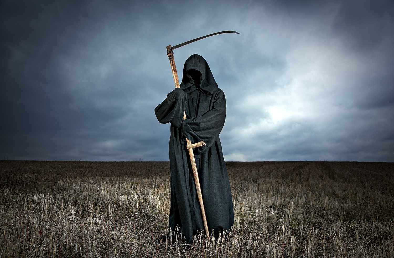 Caption: Eerie Grim Reaper at Sunset
