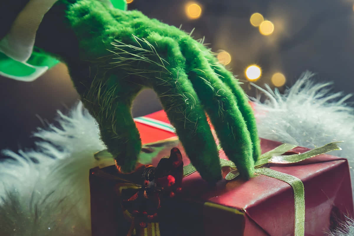 Grinch Hand Stealing Christmas Gift Wallpaper