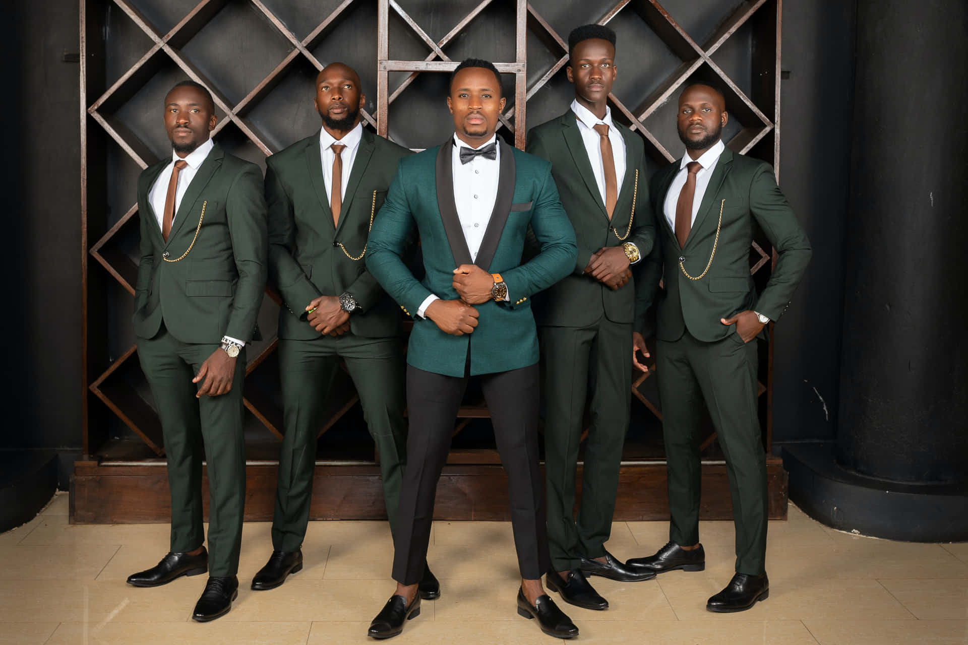 Five groomsmen stands proud in their smart suites on the wedding day