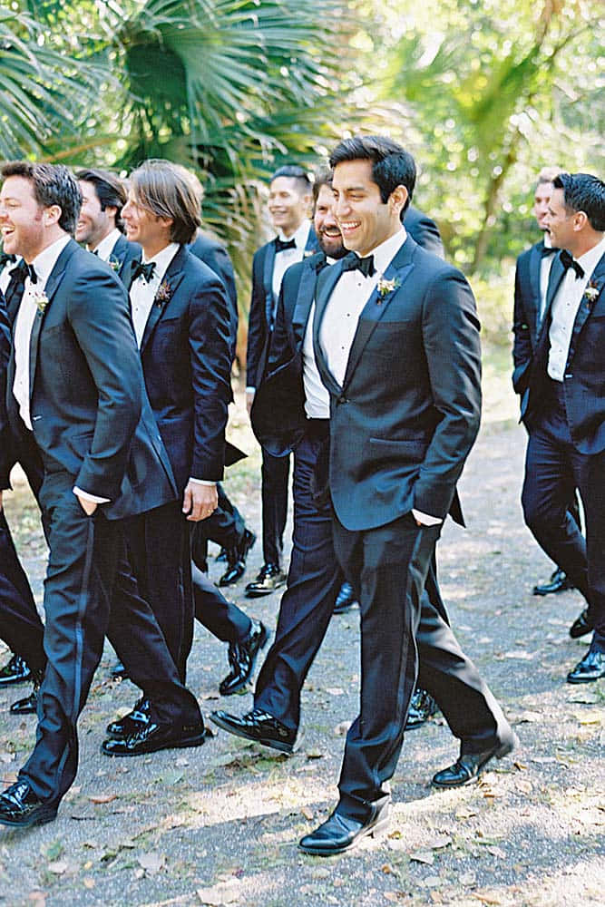 Groomsmen Walking In A Group Of Tuxedos