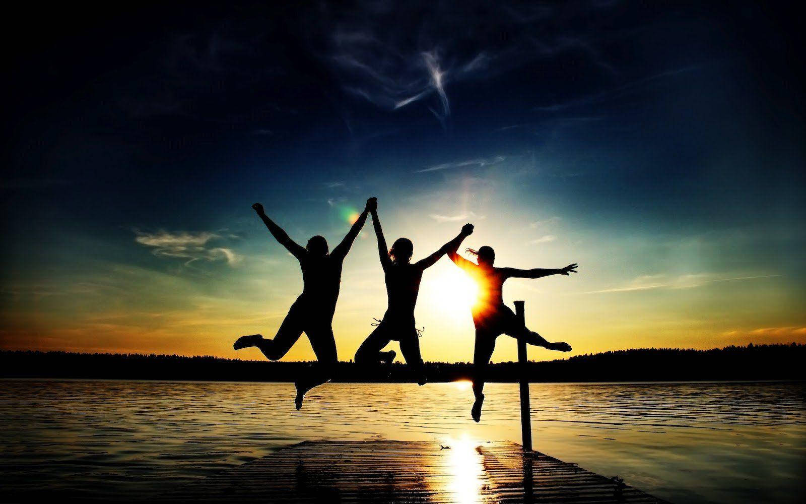 Group Jump Shot By Lake Sunset Wallpaper