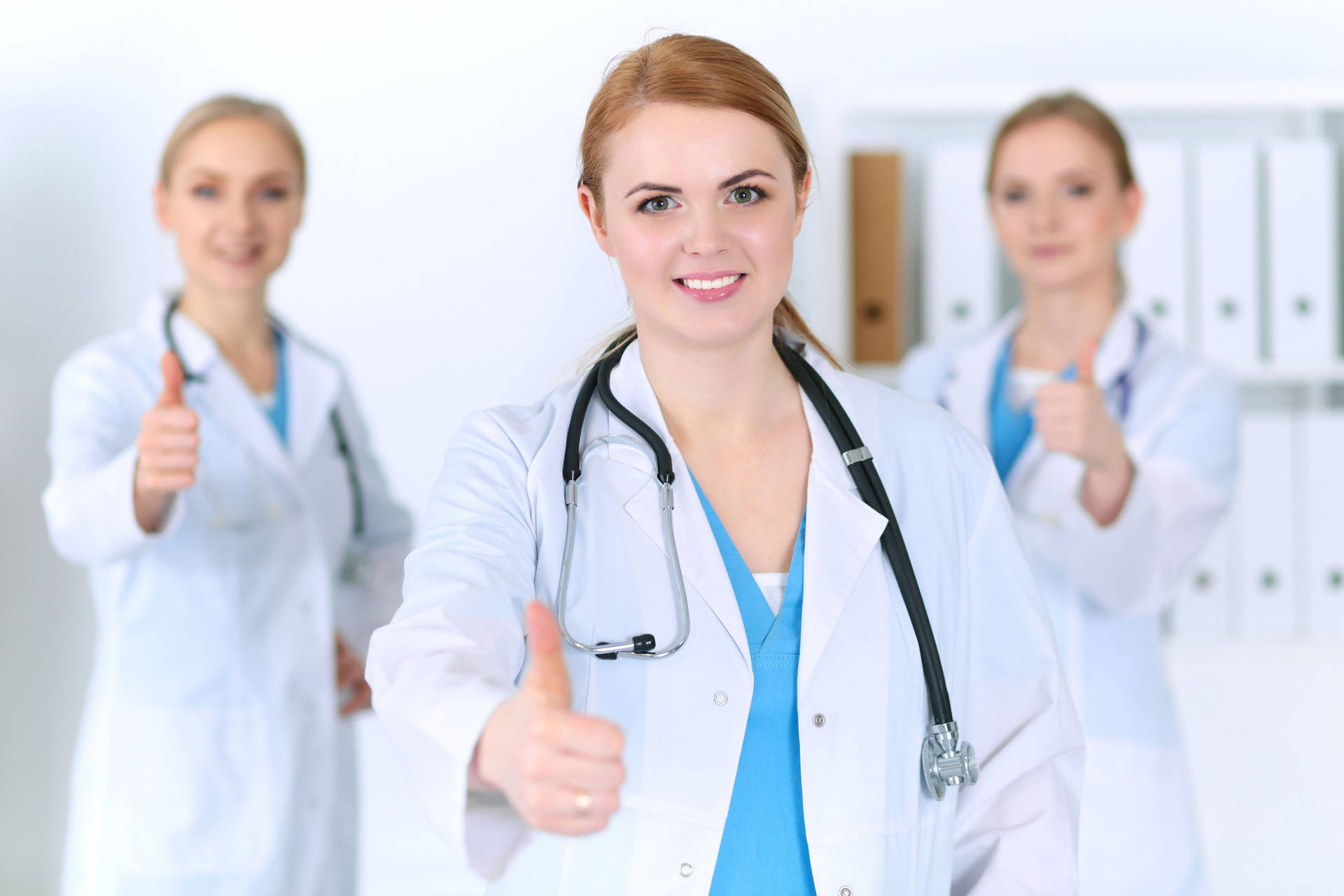 Caption: Optimistic Physicians Giving Thumbs Up Wallpaper