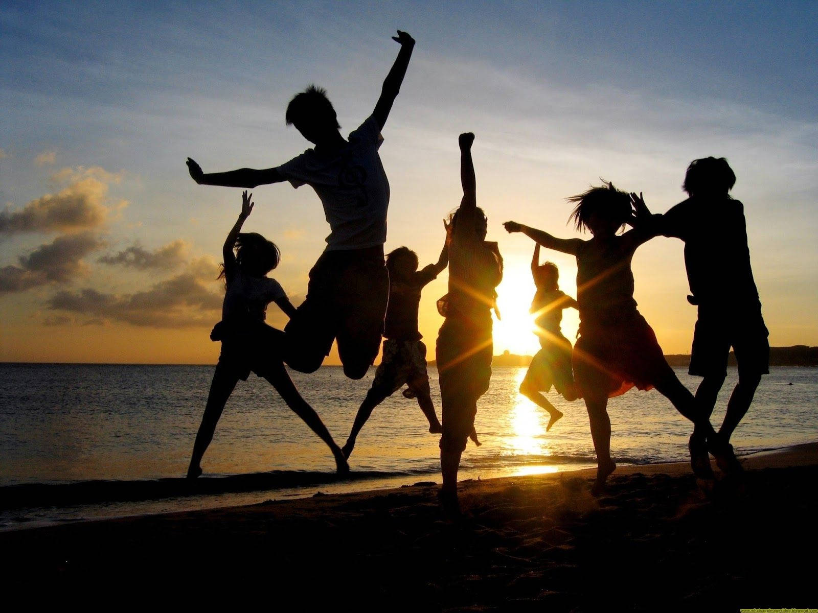 Gruppe Silhouette Hop Skydning på stranden i solnedgang Wallpaper
