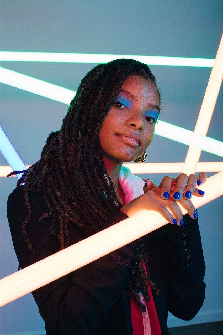 A Young Woman With Dreadlocks Holding Up Neon Lights Wallpaper