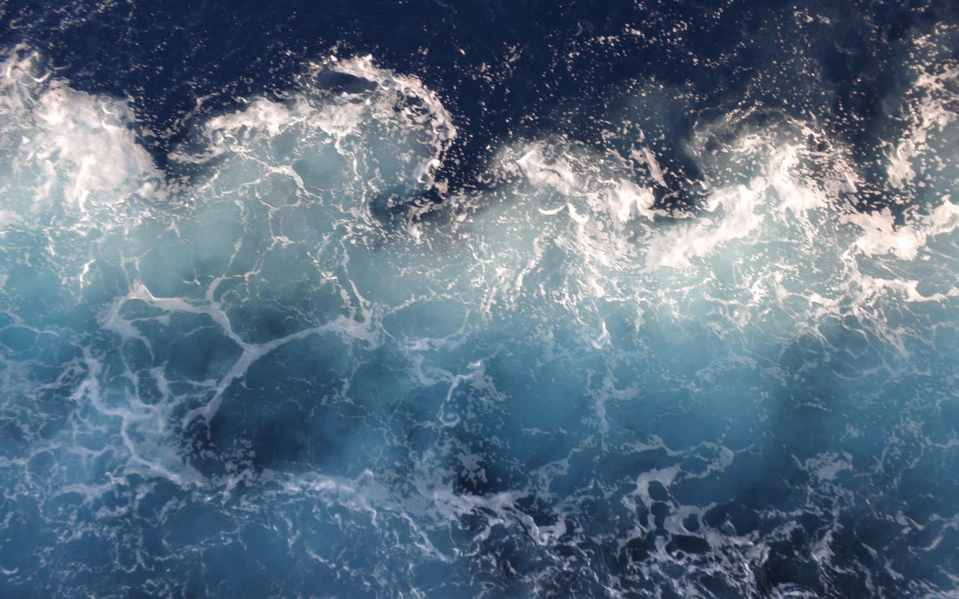 En blå bølge styrter ind i havet Wallpaper