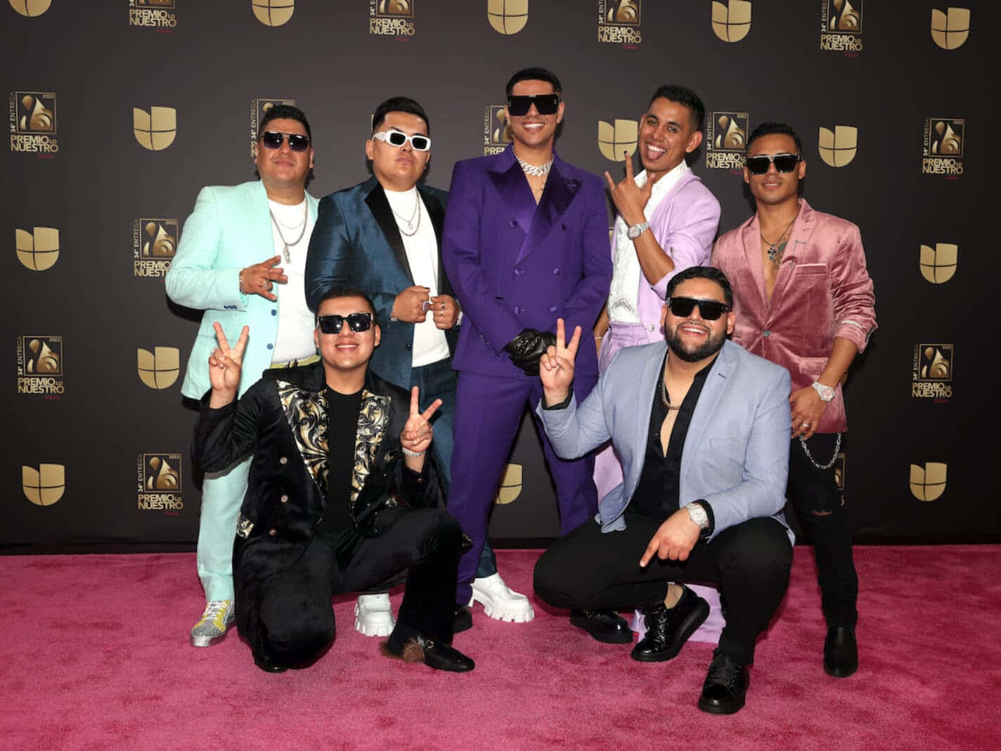 A Group Of Men In Suits Posing For A Photo On The Red Carpet Wallpaper