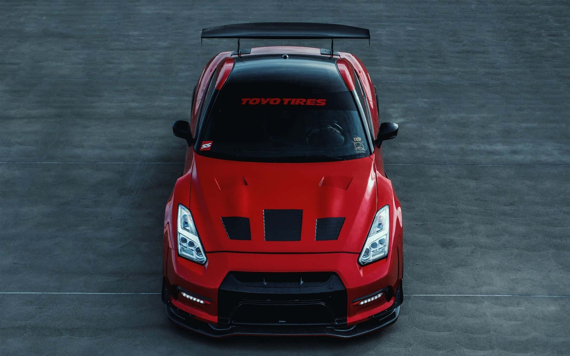 A Red Nissan Gtr - R - Is Shown In The Sky Wallpaper