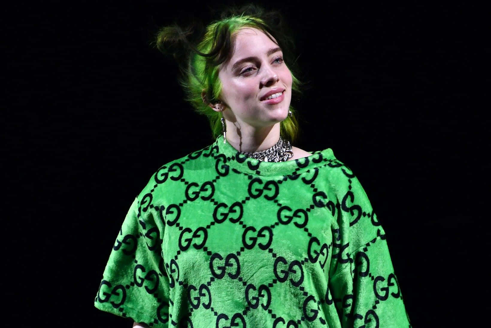 Einefrau In Einem Grünen Shirt Lächelt. Wallpaper