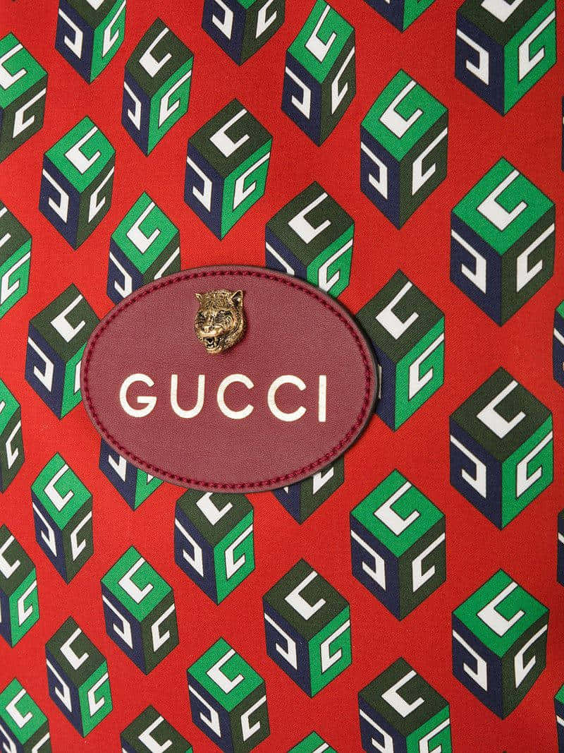 Gucci Logo On A Red Bag With Green And Blue Squares Wallpaper