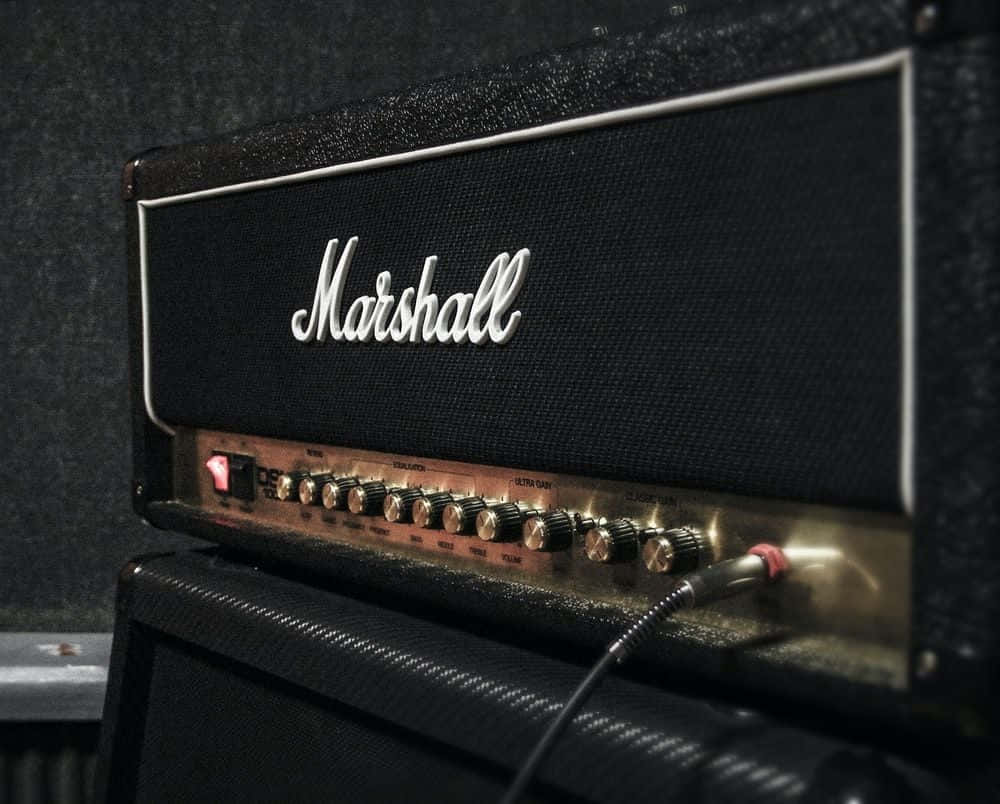 An electric guitar laying in front of an amp ready for a killer gig Wallpaper