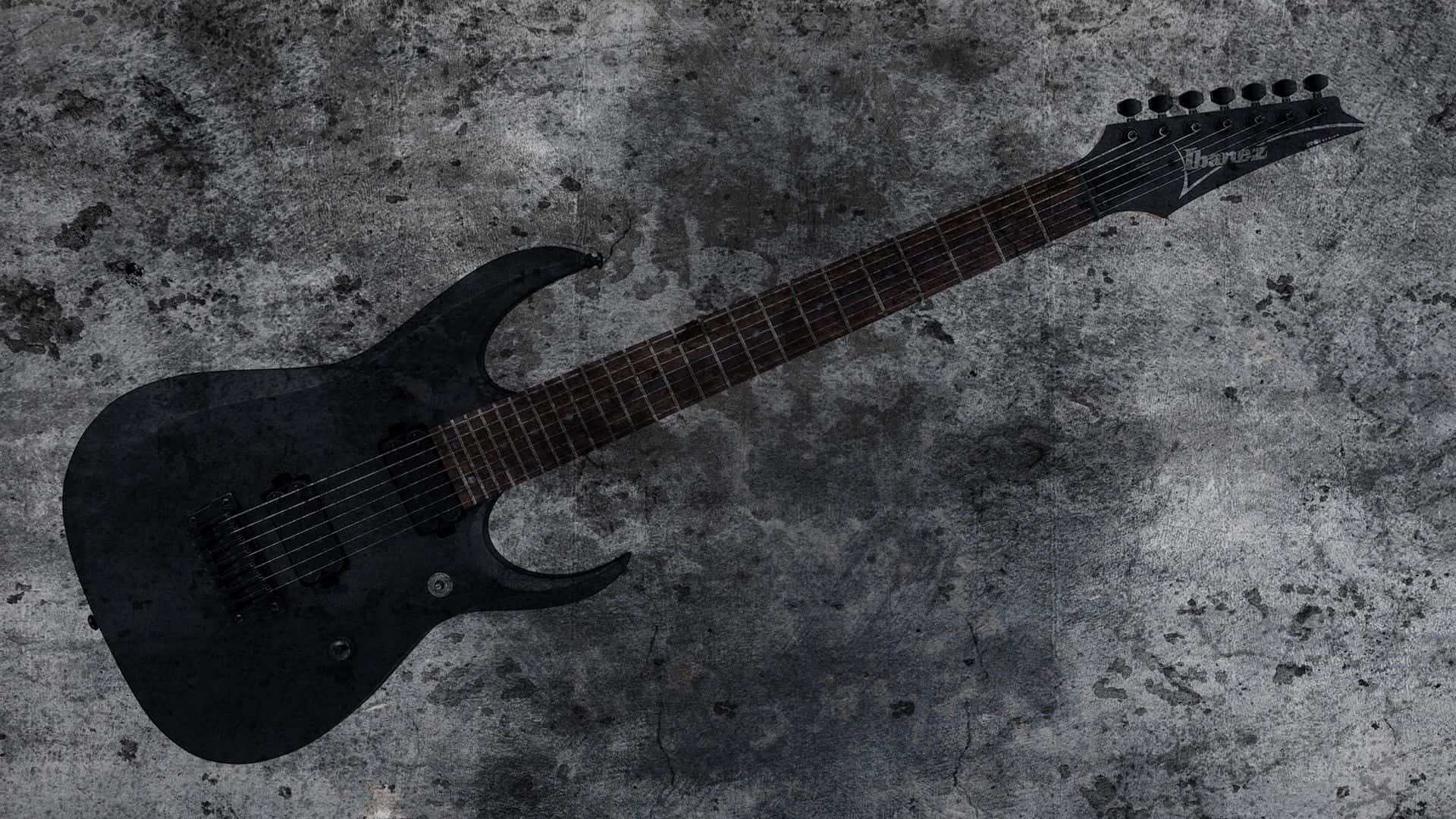 A Black Electric Guitar Is Shown Against A Concrete Wall