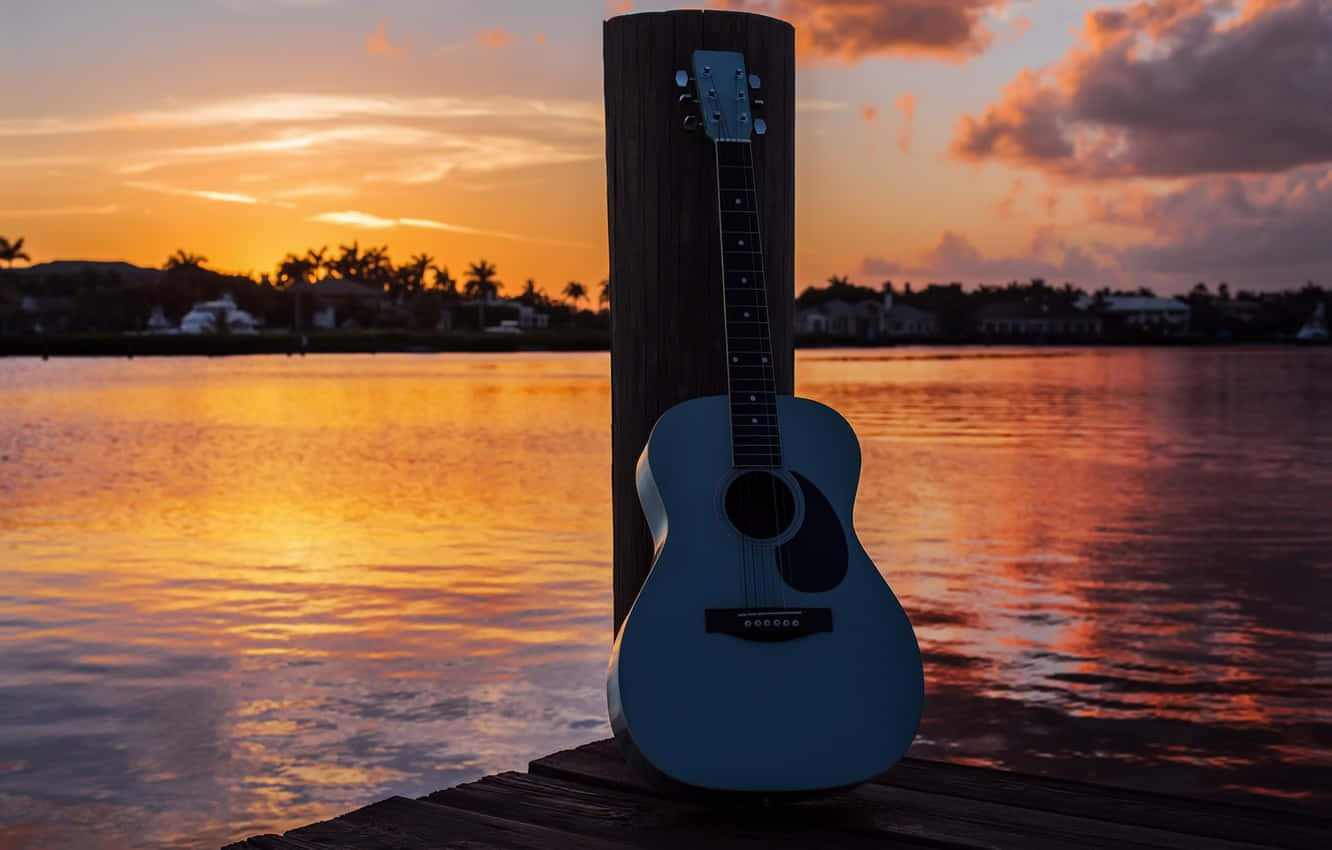akustisk guitar på en bro ved solnedgang