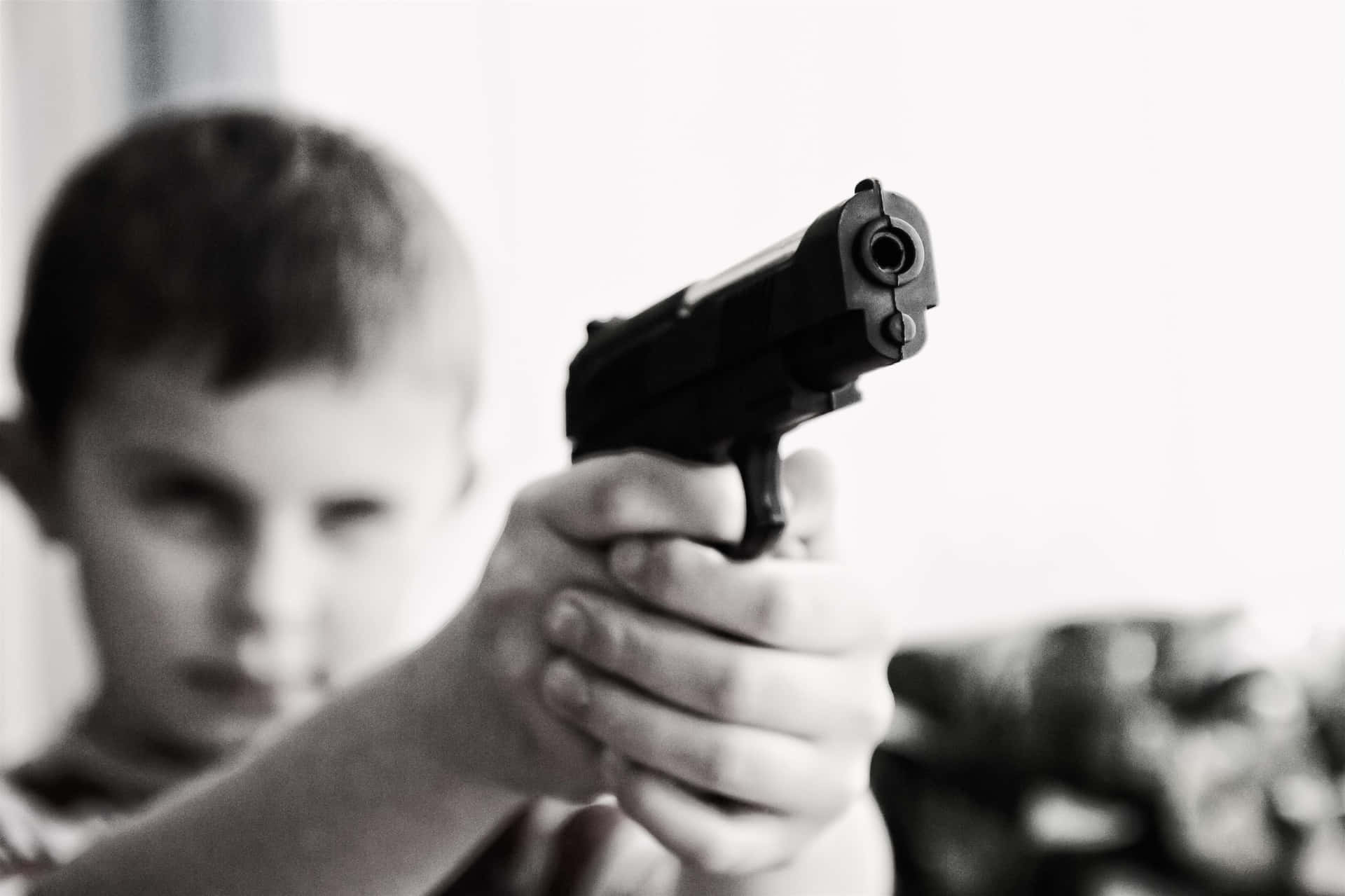 Enpojke Håller I En Pistol I Sin Hand