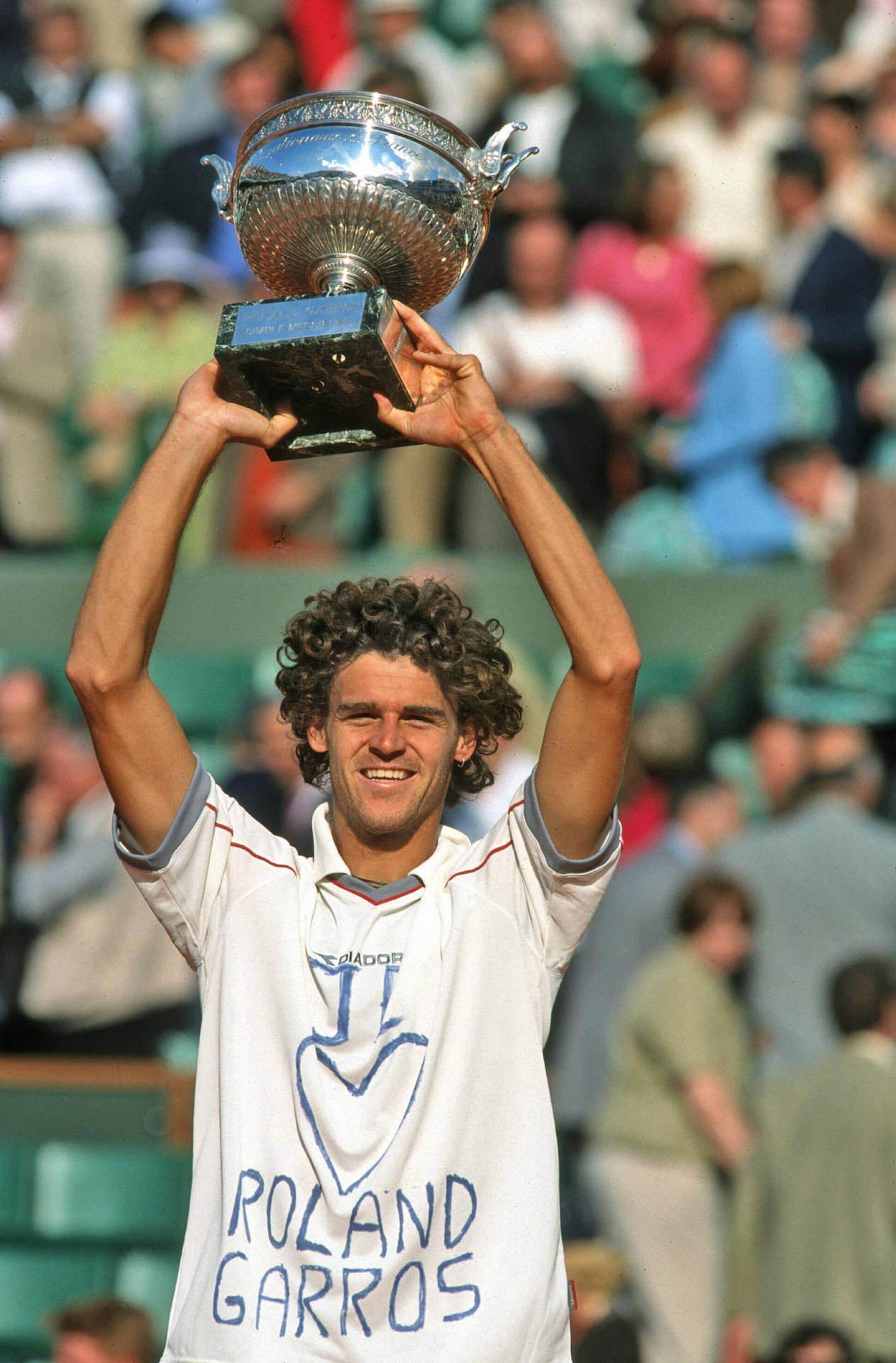 Gustavo Kuerten jubilantly lifting a trophy after a match victory. Wallpaper