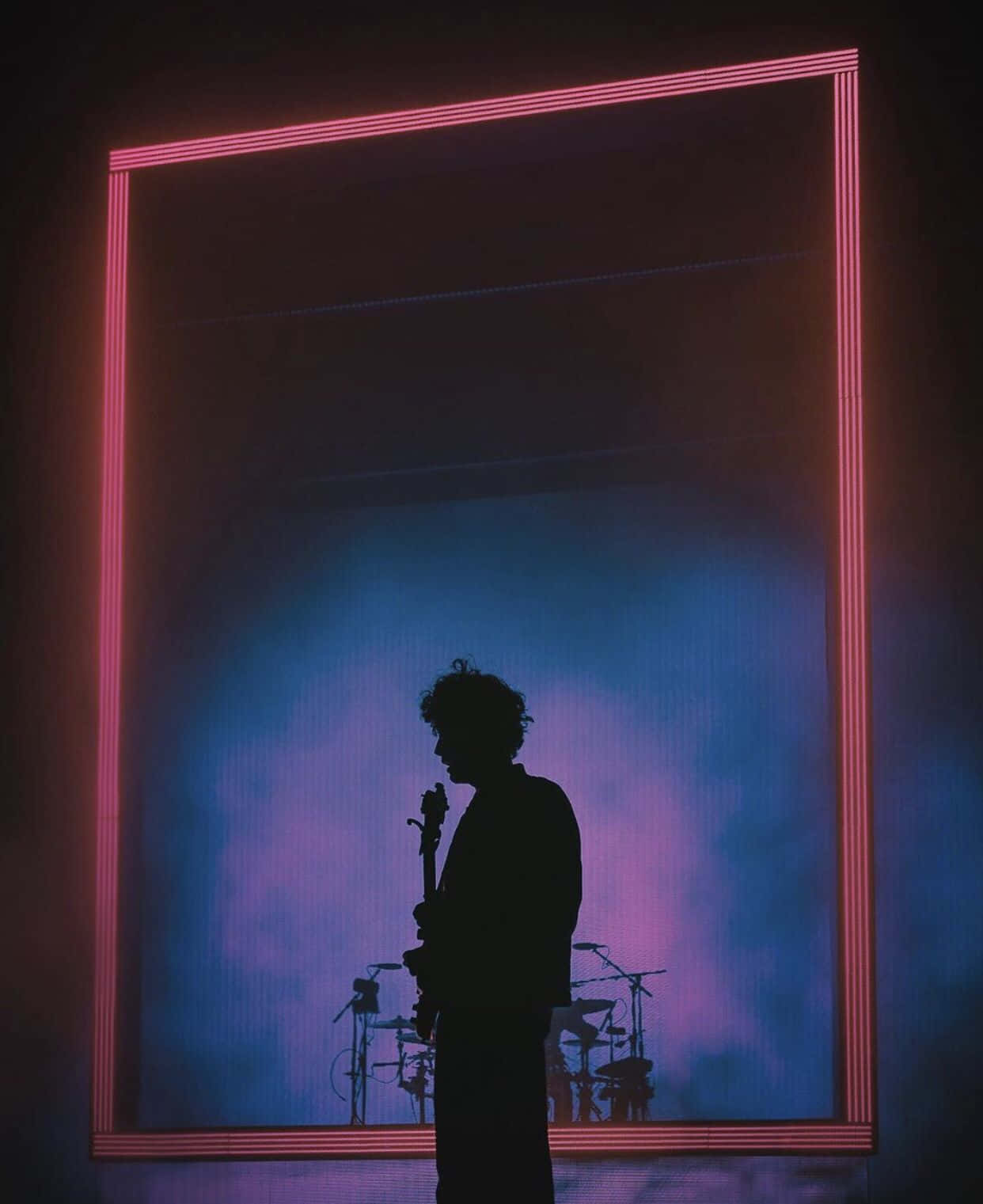 A Silhouette Of A Man Standing In Front Of A Large Neon Frame Wallpaper