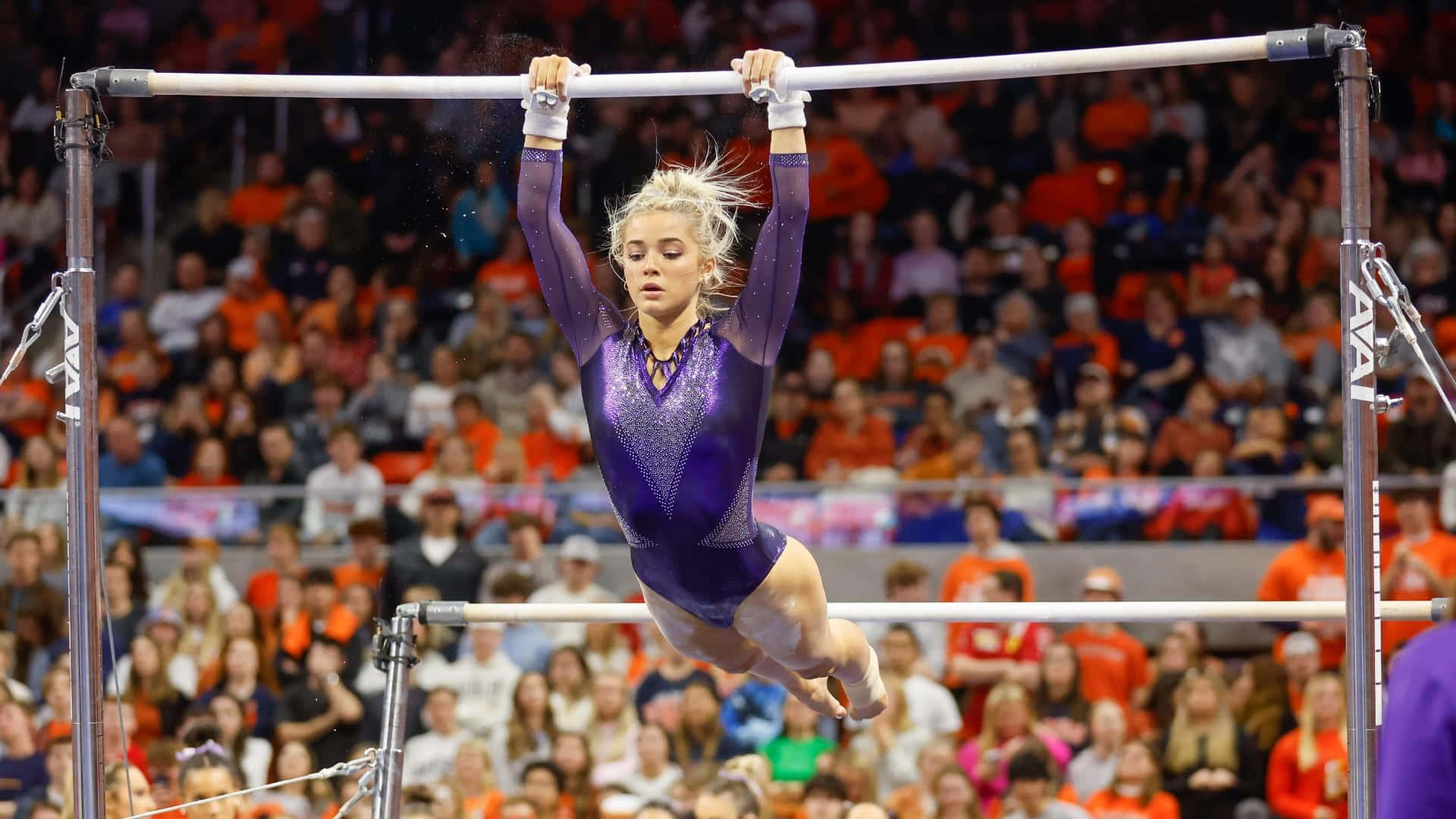 Gymnast Performing Uneven Bars Routine Wallpaper