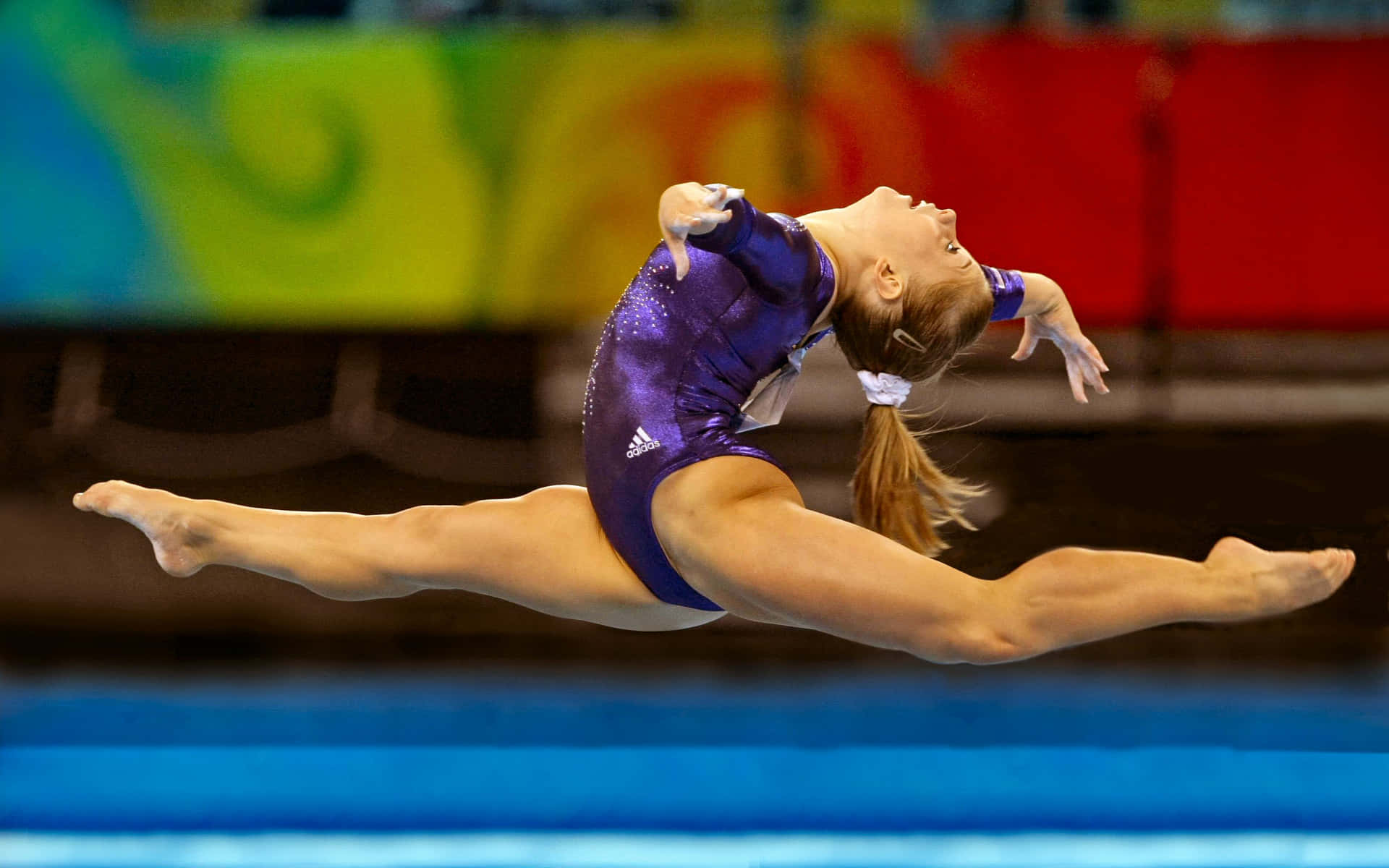 A gymnast gracefully performing her routine on the balance beam
