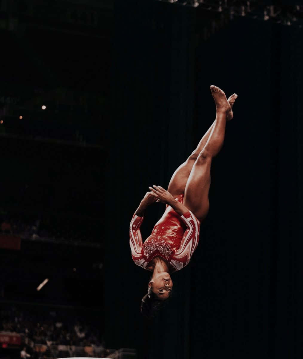 A gymnast shows her strength during an aerial maneuver