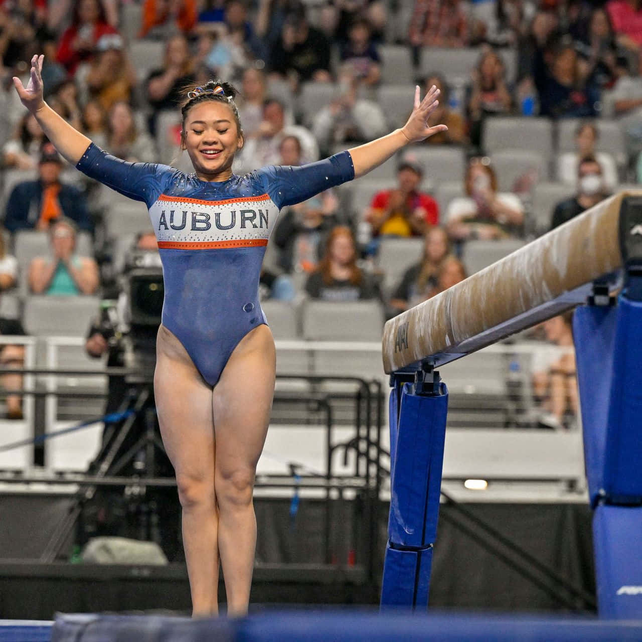 Download A Woman Is On The Balance Beam At A Competition