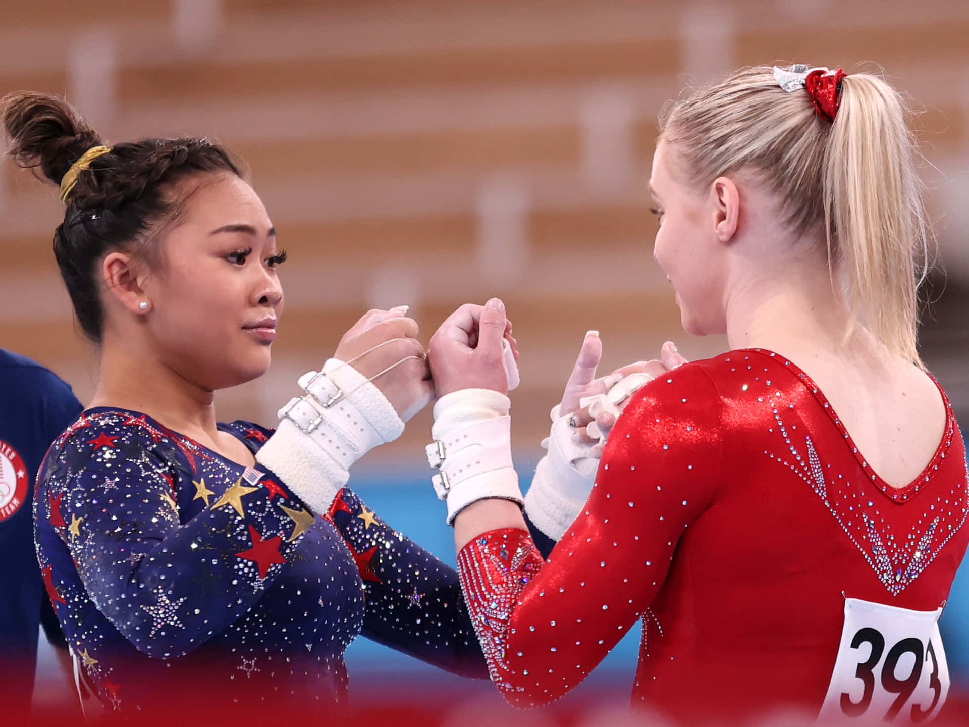 Two Women Are Shaking Hands While Performing Gymnastics