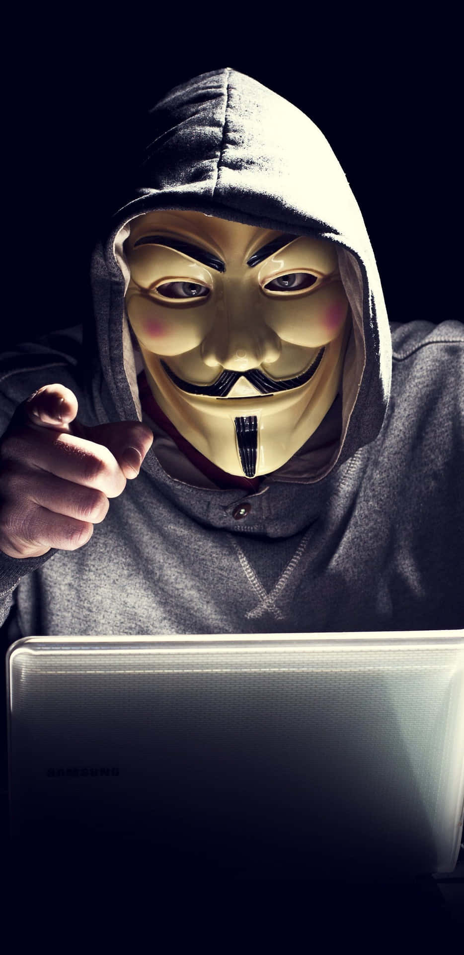A Man In A Mask Is Using A Laptop