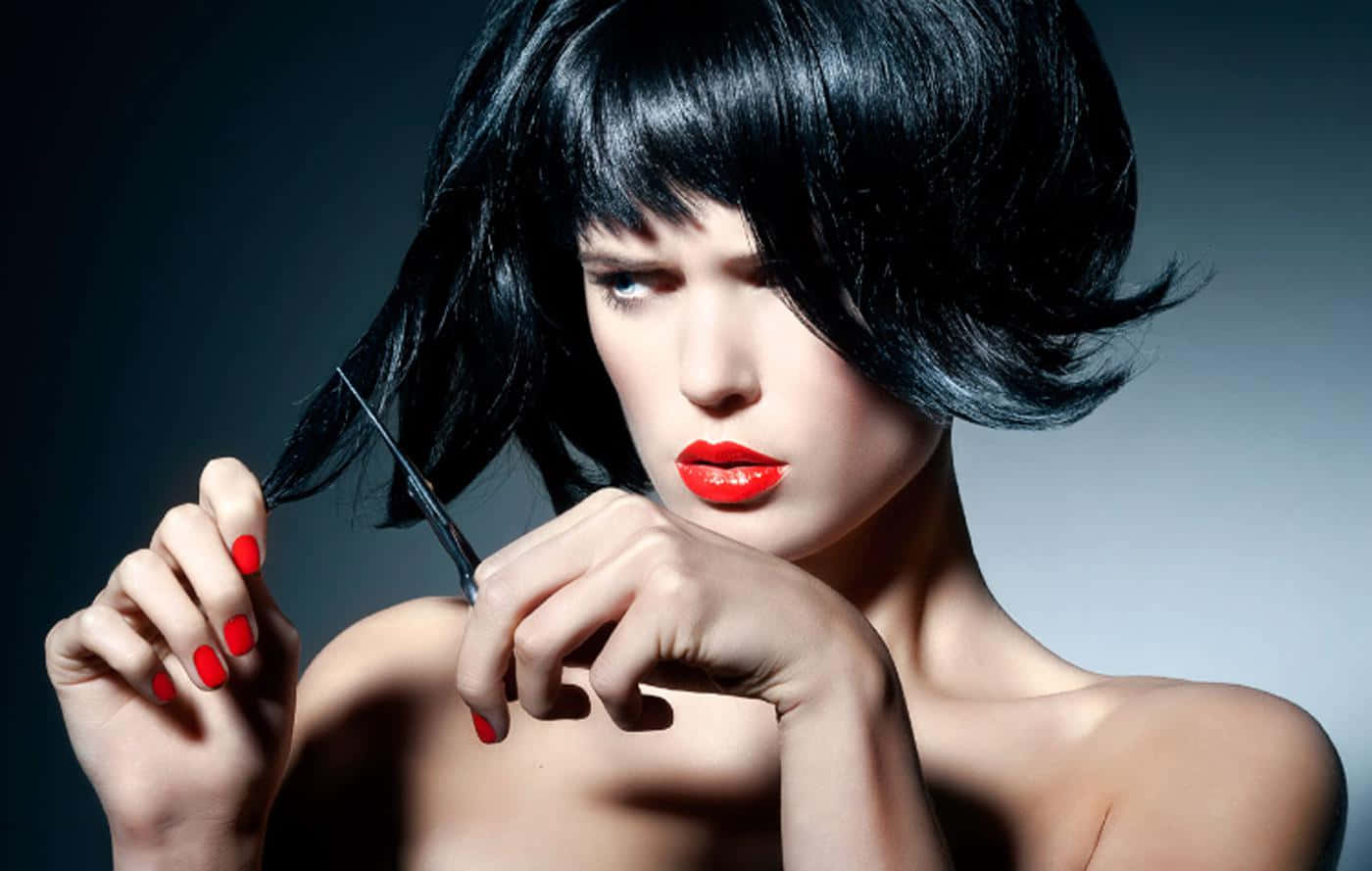 A Woman With Black Hair And Red Nails Holding A Pair Of Scissors