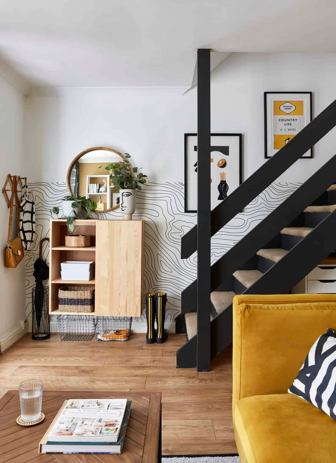 A Yellow Couch And Black Stairs In A Living Room Wallpaper