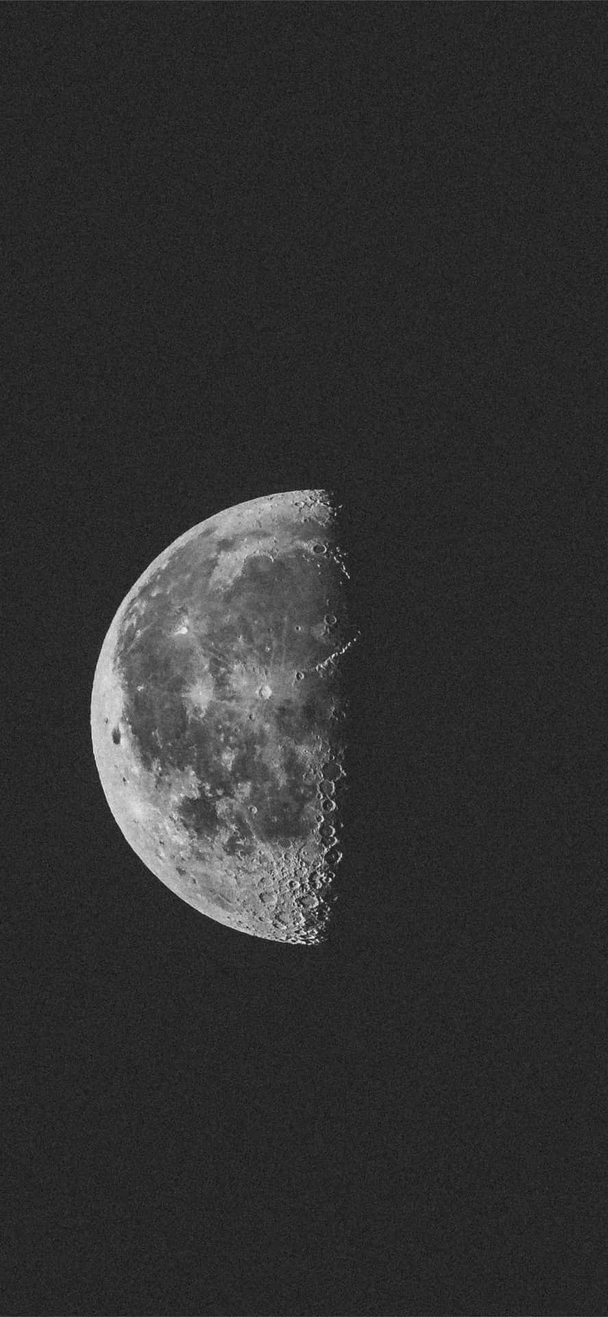 Et sort-hvidt foto af månen med stjerner i det. Wallpaper