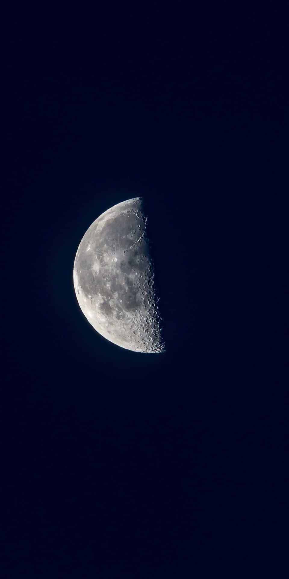 A breathtaking view of the half moon glowing in the night sky
