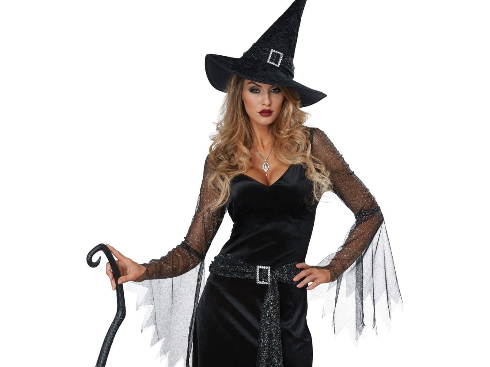 A Woman In A Black Witch Costume Holding A Broom