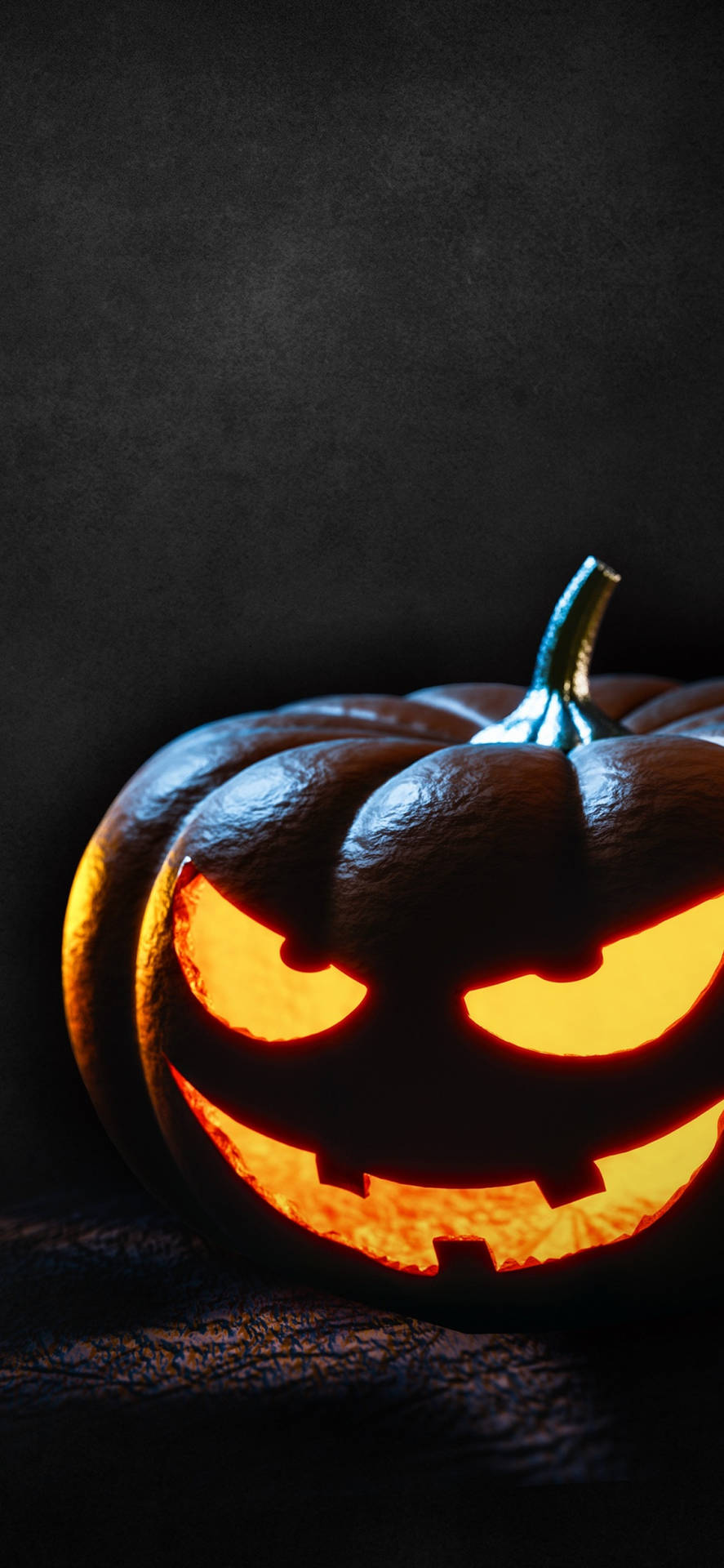 A Pumpkin With Glowing Eyes On A Dark Background Wallpaper