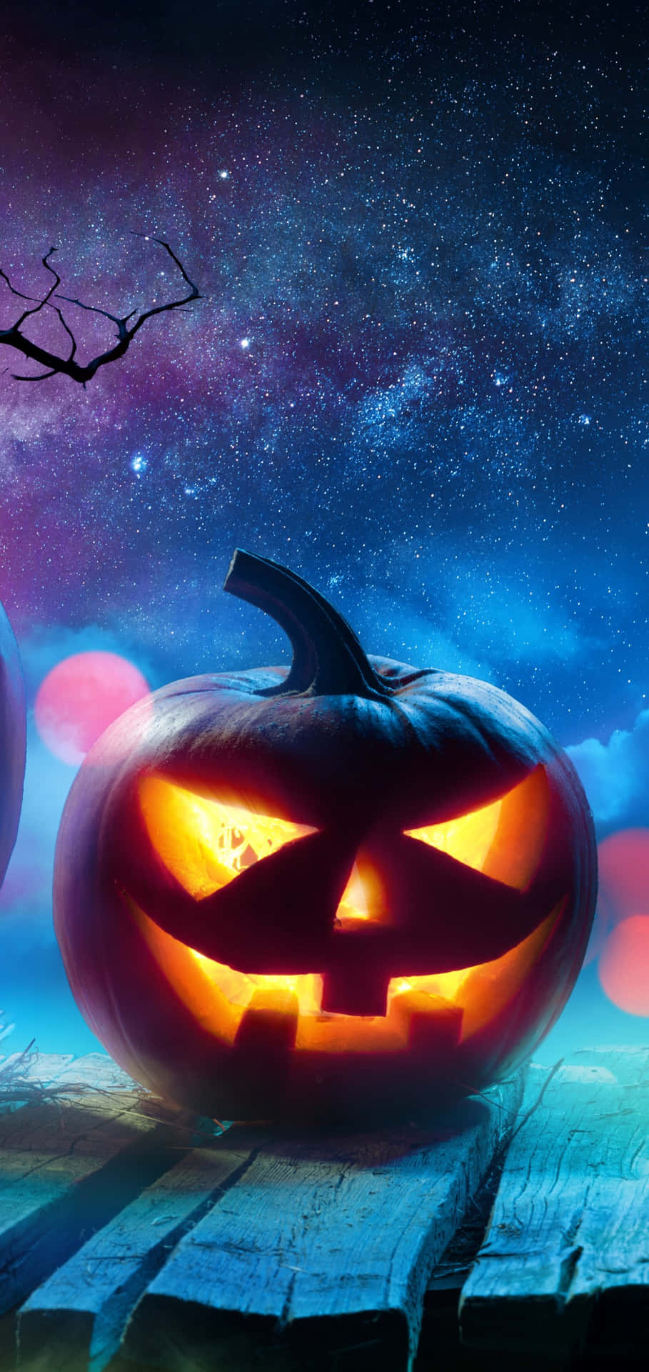 Halloween Pumpkin Glowing Under Starry Sky Wallpaper