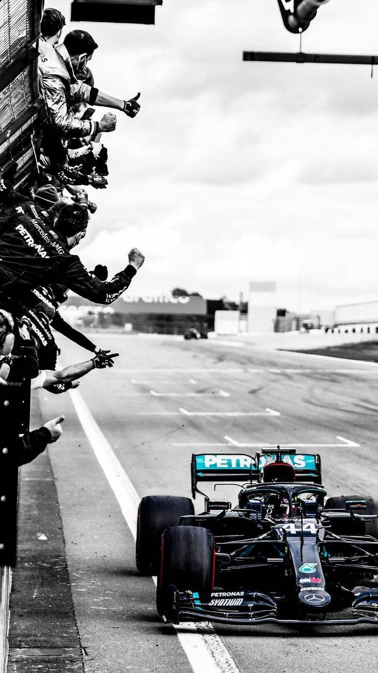 A Mercedes F1 Car Is Being Driven By Fans Wallpaper