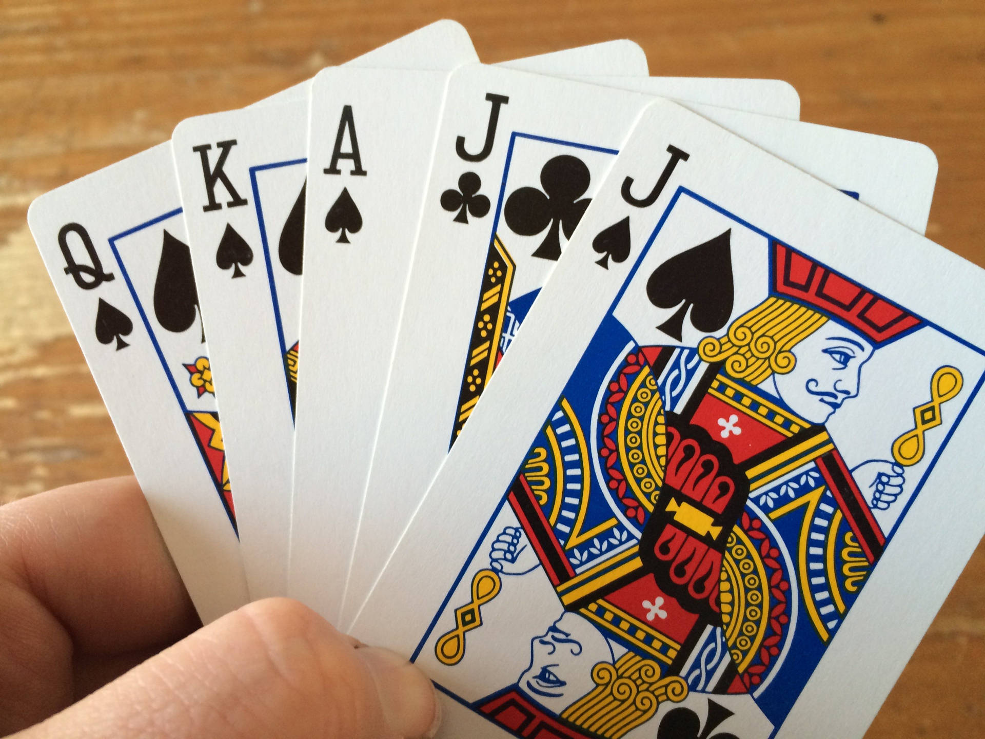 Hand Holding Five Euchre Playing Cards Wallpaper