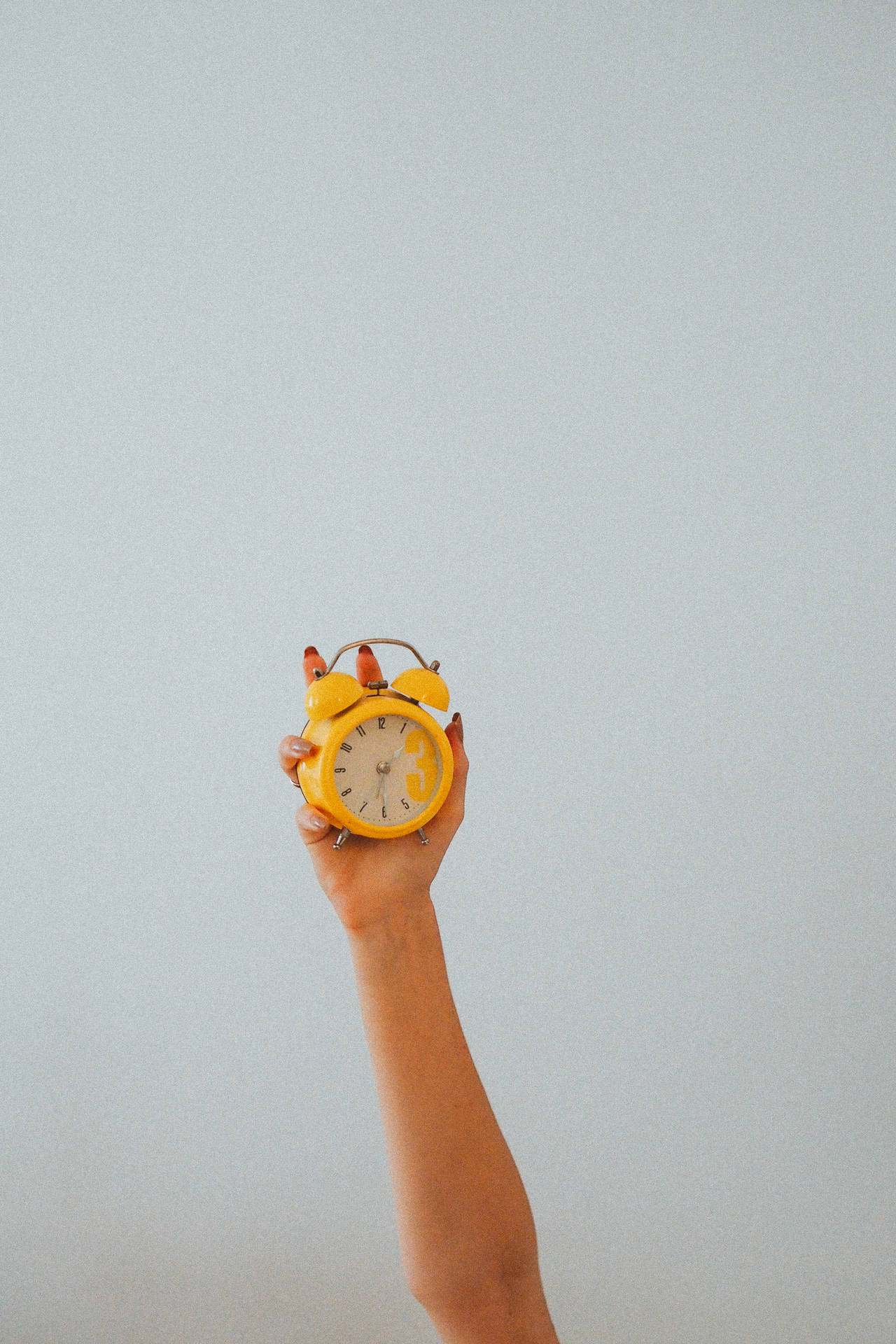 Hand Holding Yellow Alarm Clock Wallpaper