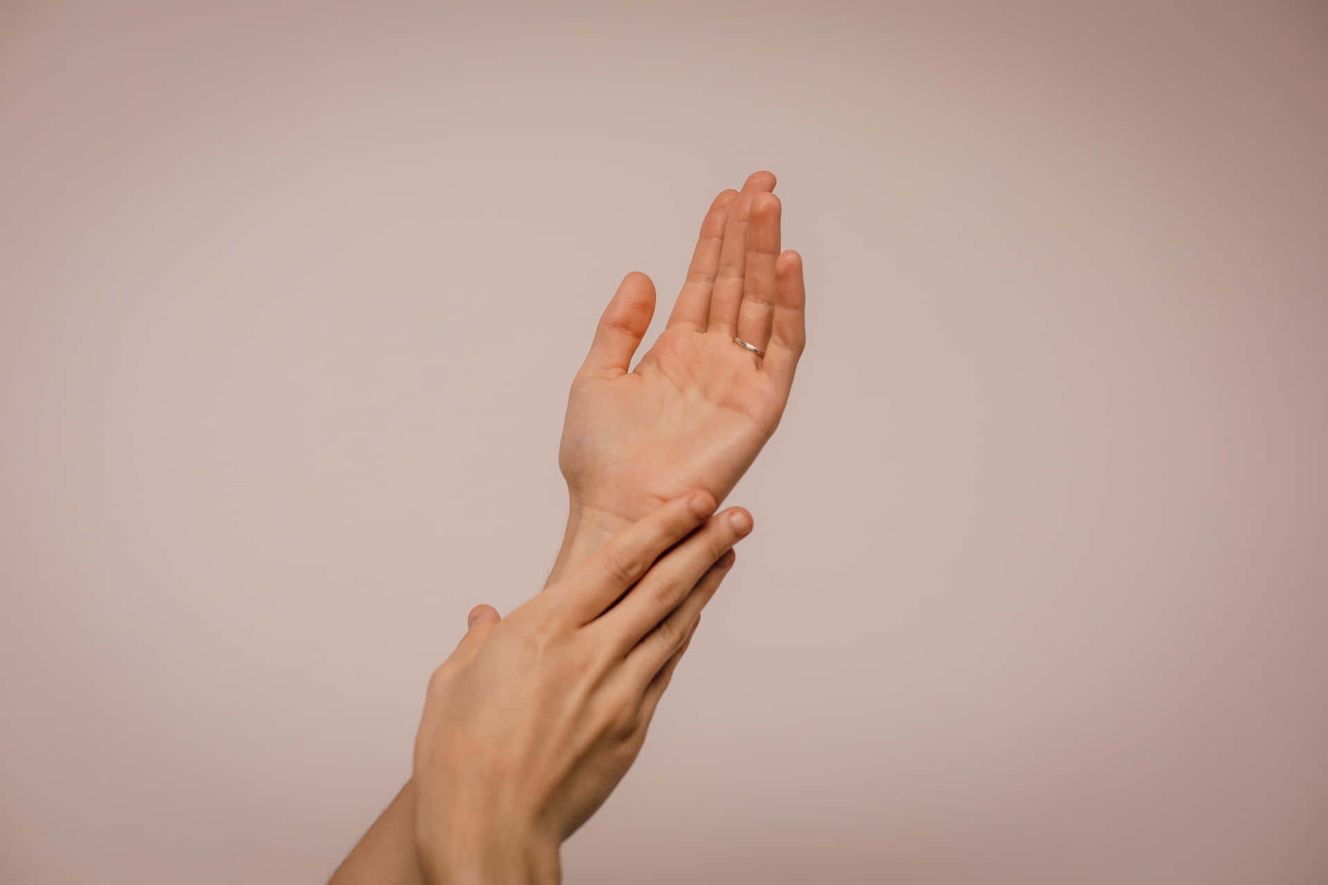 A pair of hands reaching up to the sky