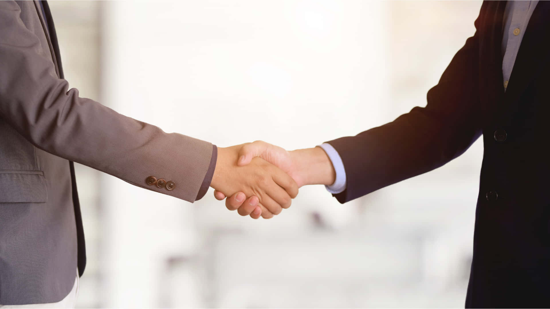 Businessmen Handshake In White Wall Front Picture