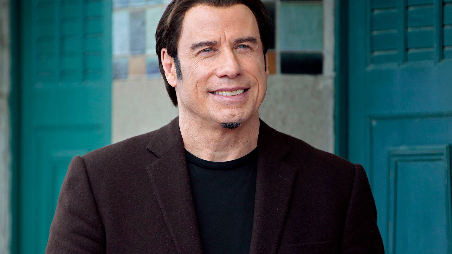 Hollywood Icon John Travolta Looking Handsome in a Black Suit Wallpaper