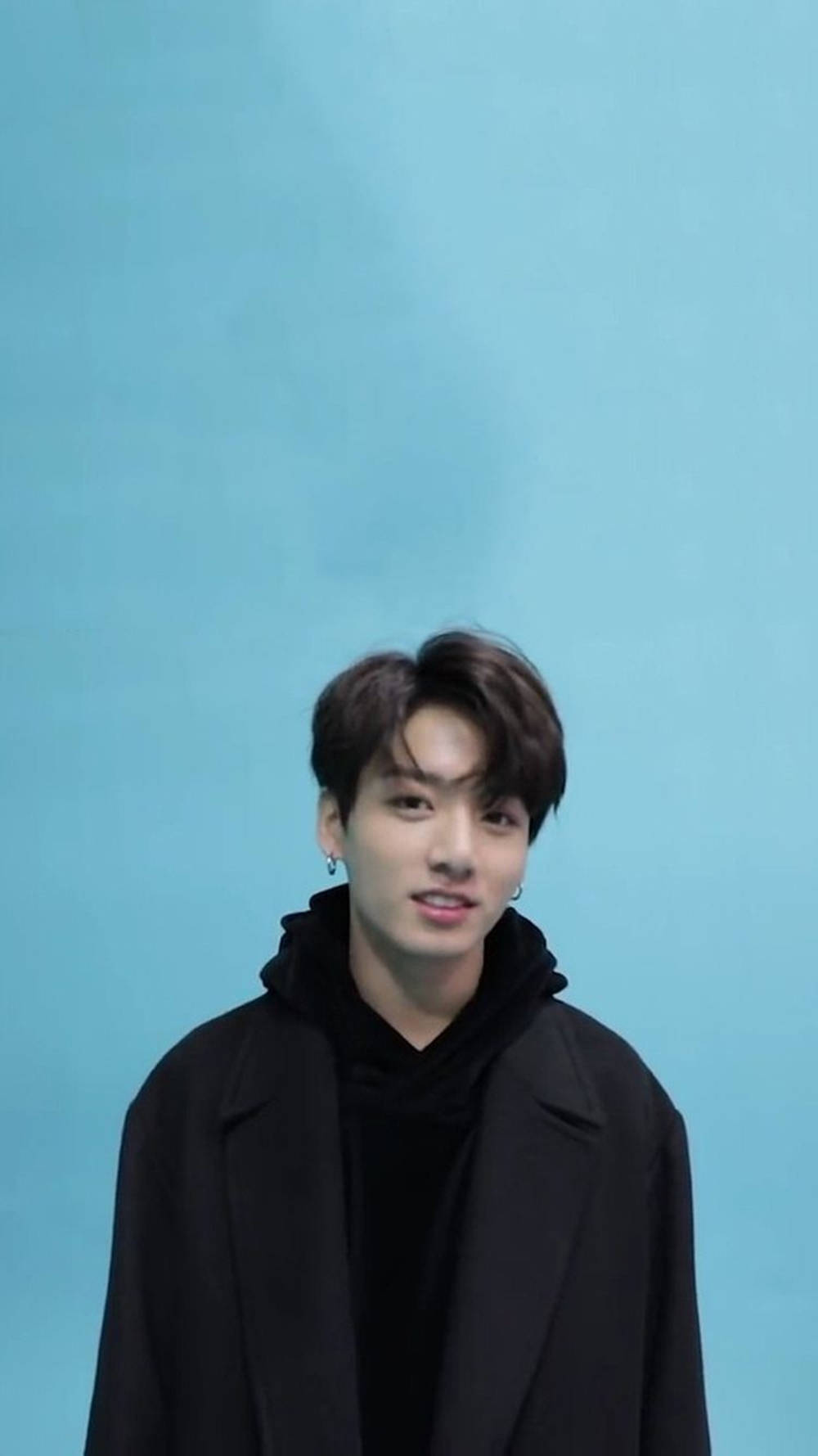 Handsome BTS JK Portrait Over Pastel Blue Wallpaper