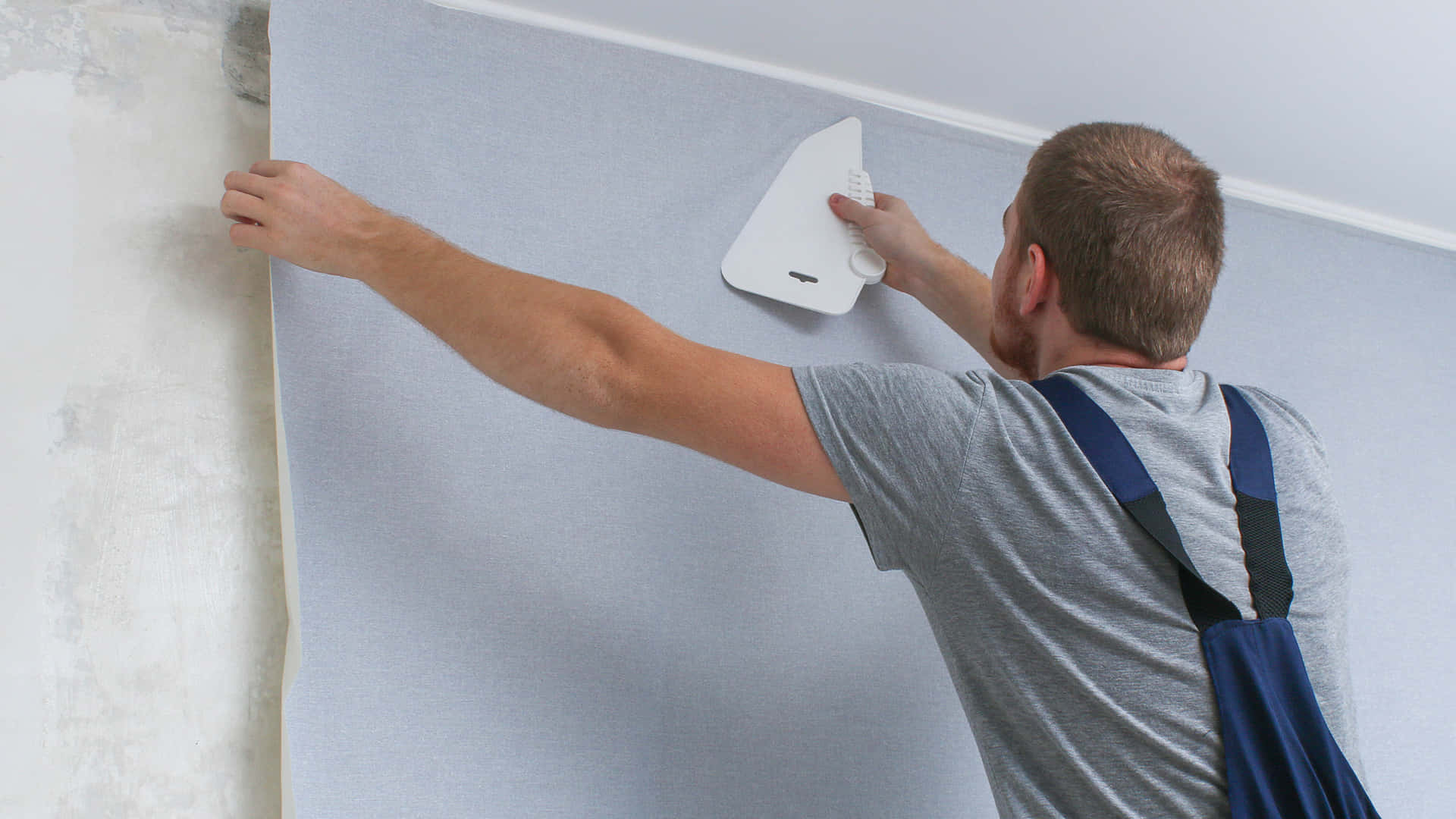 Handyman Doing Some Repairs In The Living Room Wallpaper