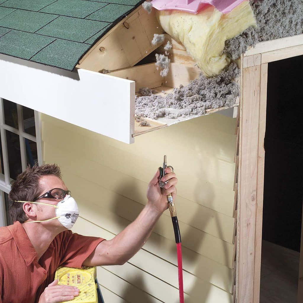 A Man Is Using A Tool To Remove The Insulation From A Roof