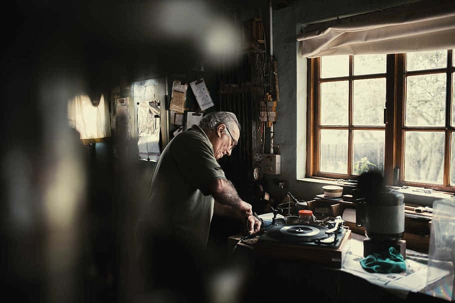 An Old Man Working In His Workshop