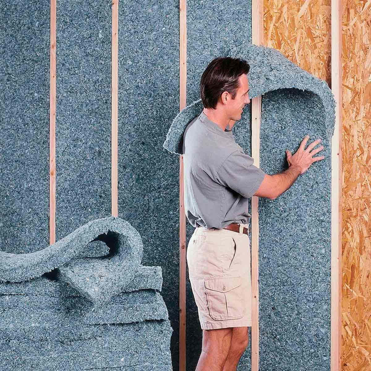 A Man Is Standing Next To A Wall Of Insulation