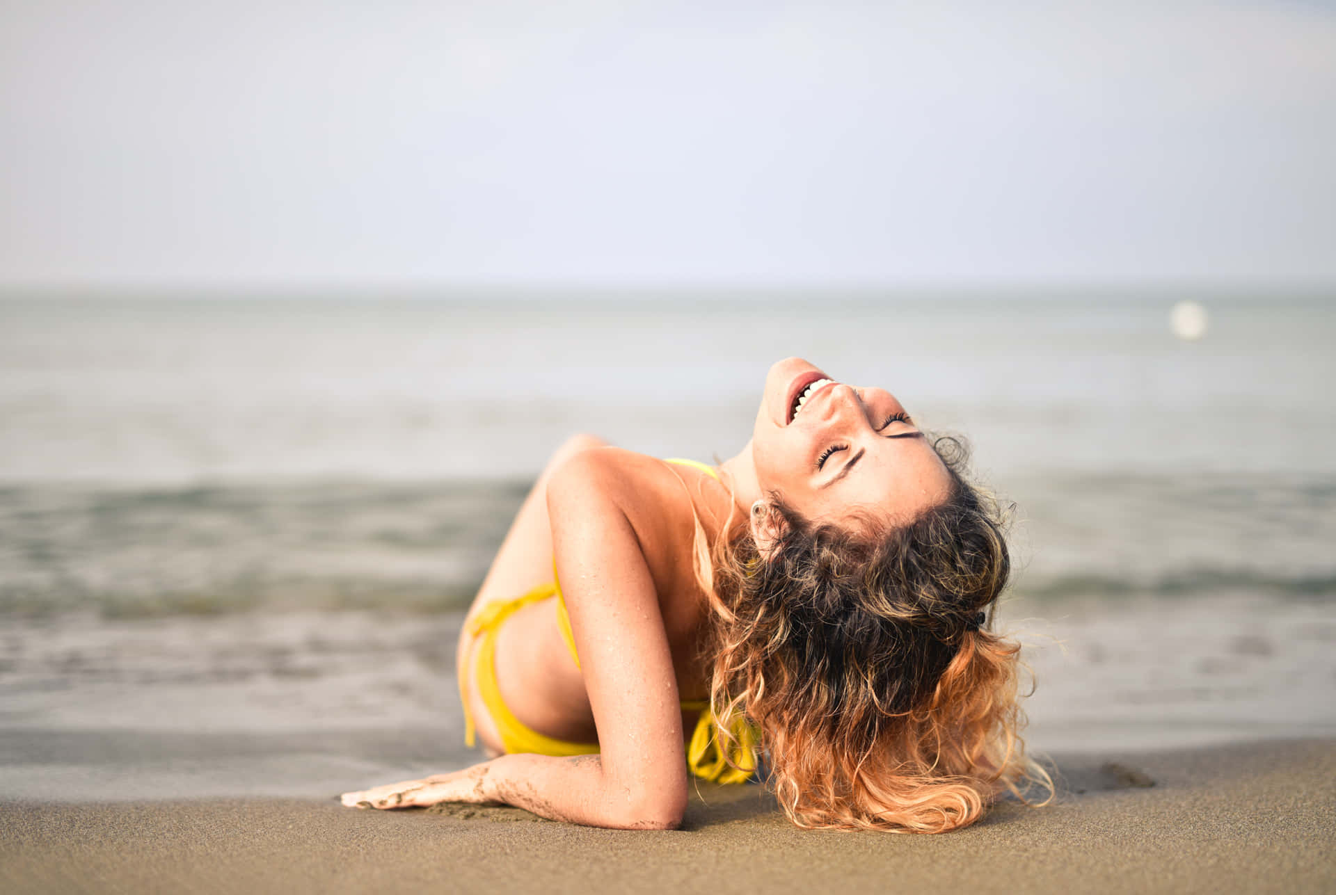 Enkvinde I En Gul Bikini Ligger På Stranden